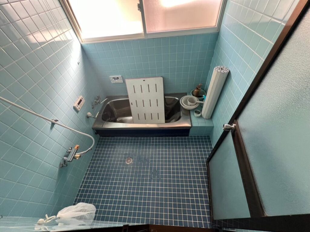 朝来市の施工前、青いモザイクタイル床とステンレス浴槽の浴室