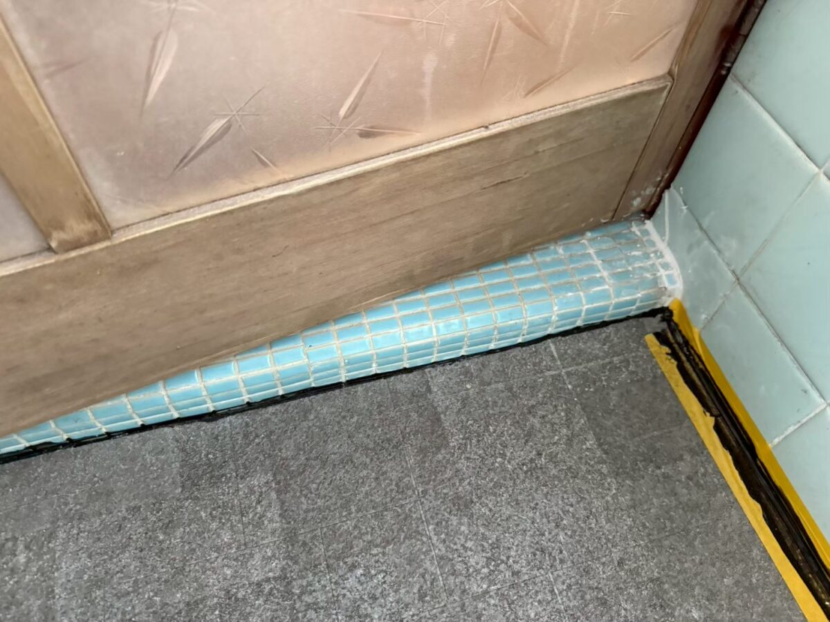 施工前　浴室ドア下に打たれたDIYのコーキング