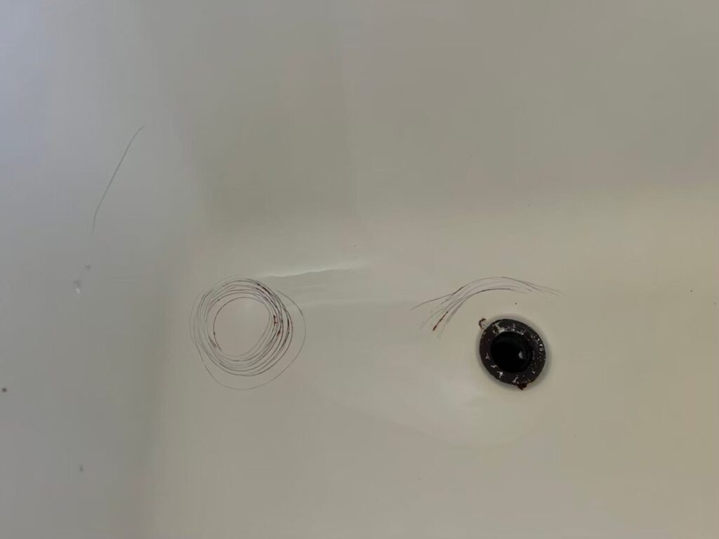 太子町の施工前、浴槽の排水口まわり。底に細い線で丸く囲んだような跡がある