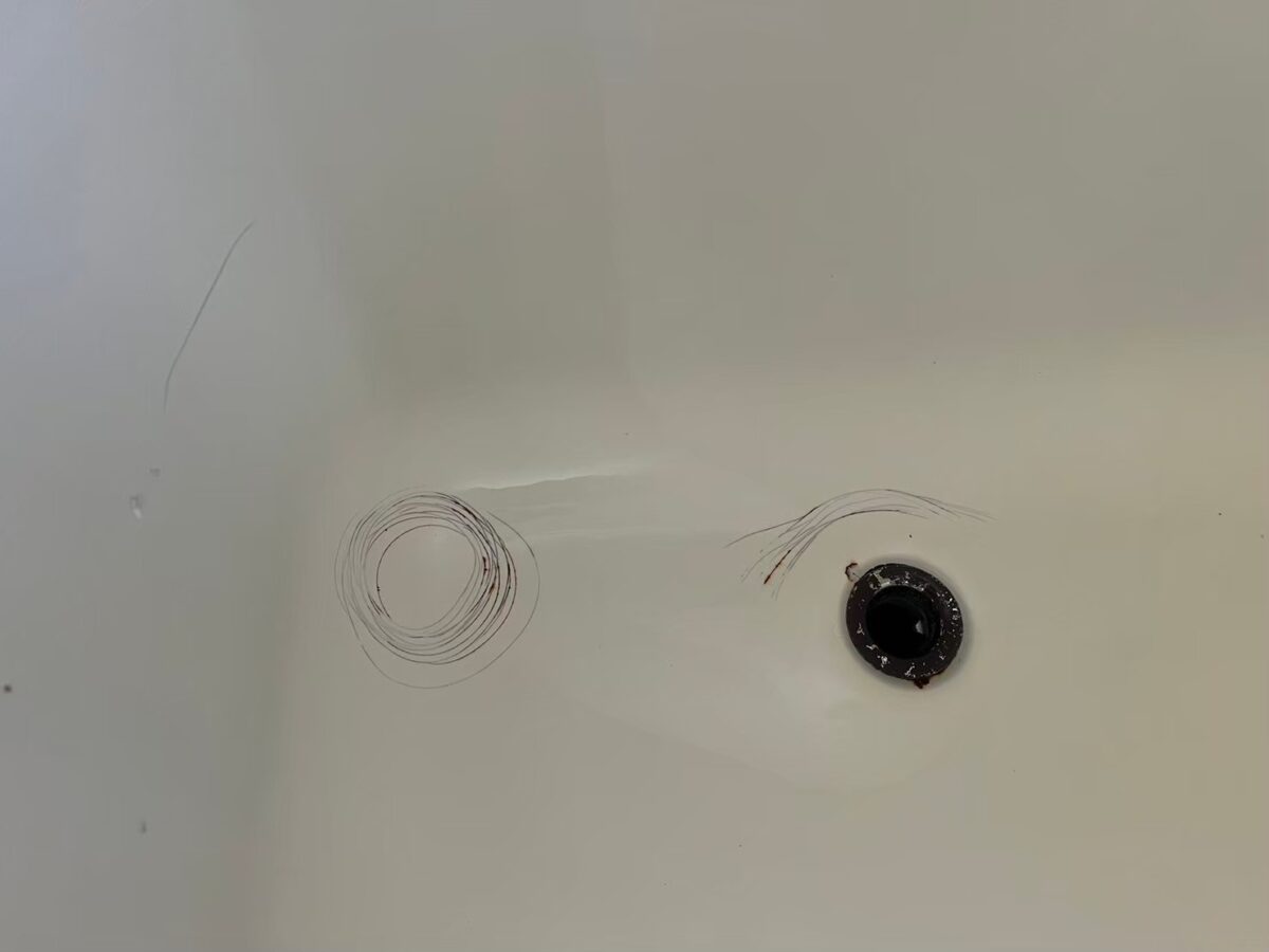 太子町の施工前、浴槽の排水口まわり。底に細い線で丸く囲んだような跡がある