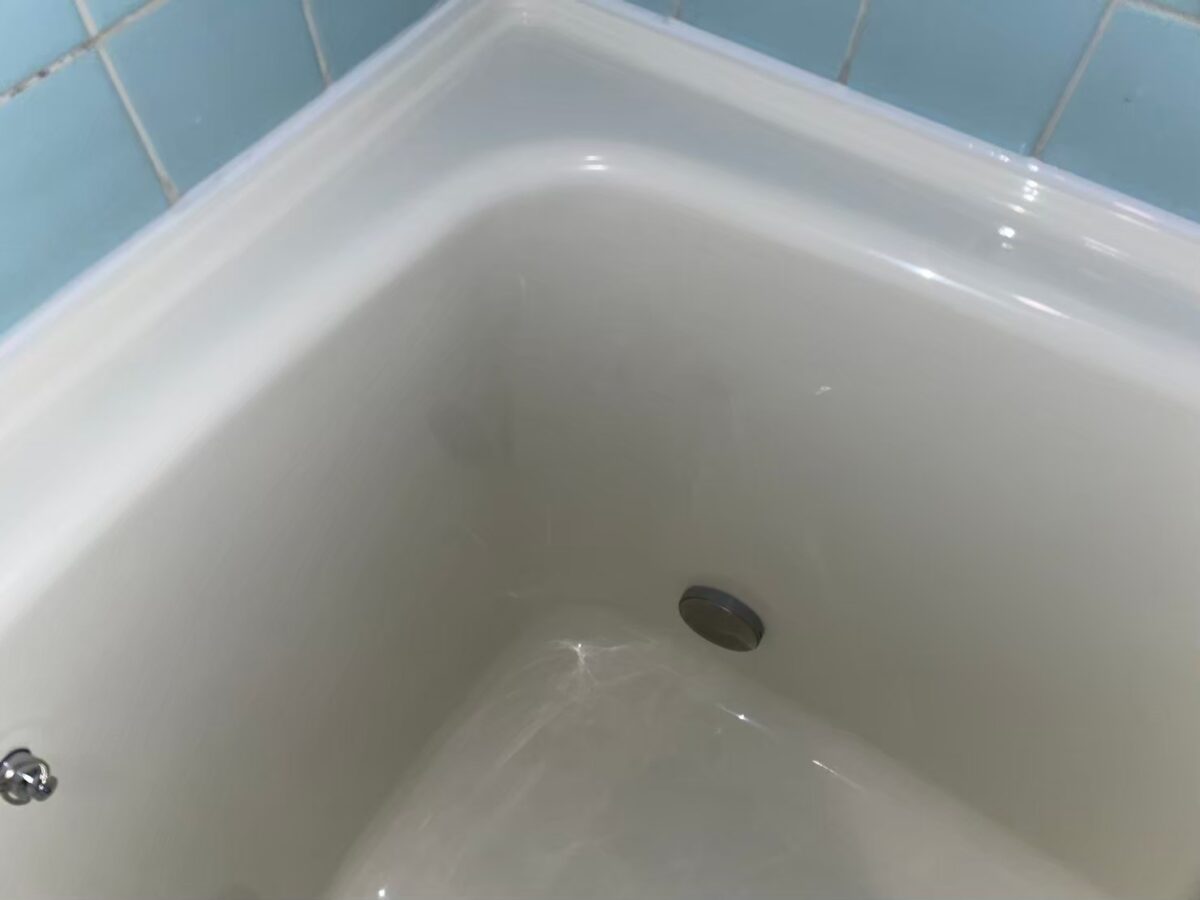 施工後、浴槽の内側の角と排水口まわり。ライトアイボリーでなめらかに仕上がっている