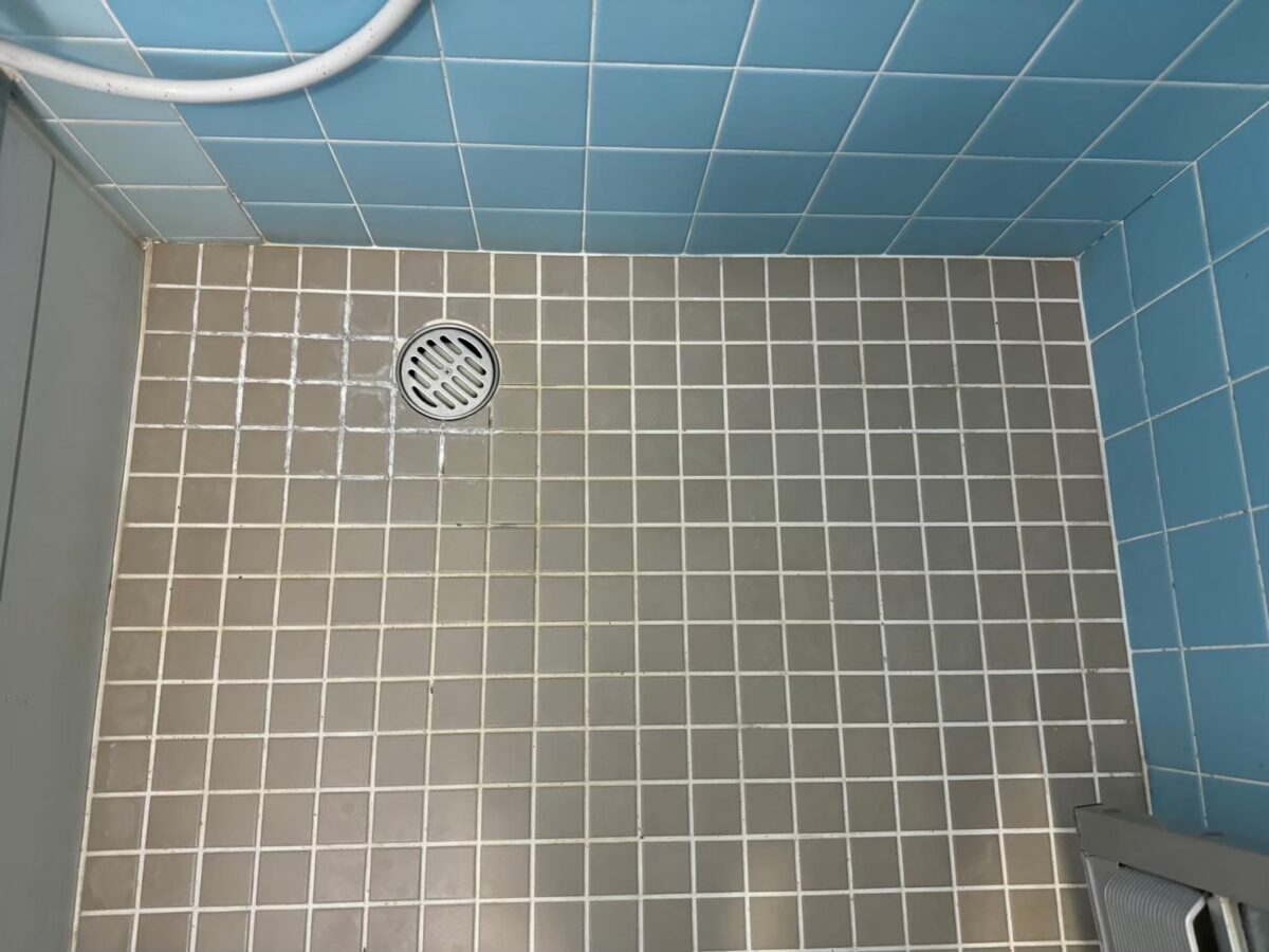 施工前、排水口のある奥の壁側を見たところ。排水口のまわりの目地が白っぽくなっている