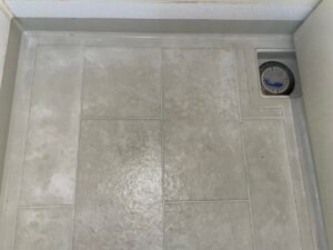 施工前の床を真上から。白く色が抜けた部分に茶色いシミと黒い点状の汚れが混ざっている