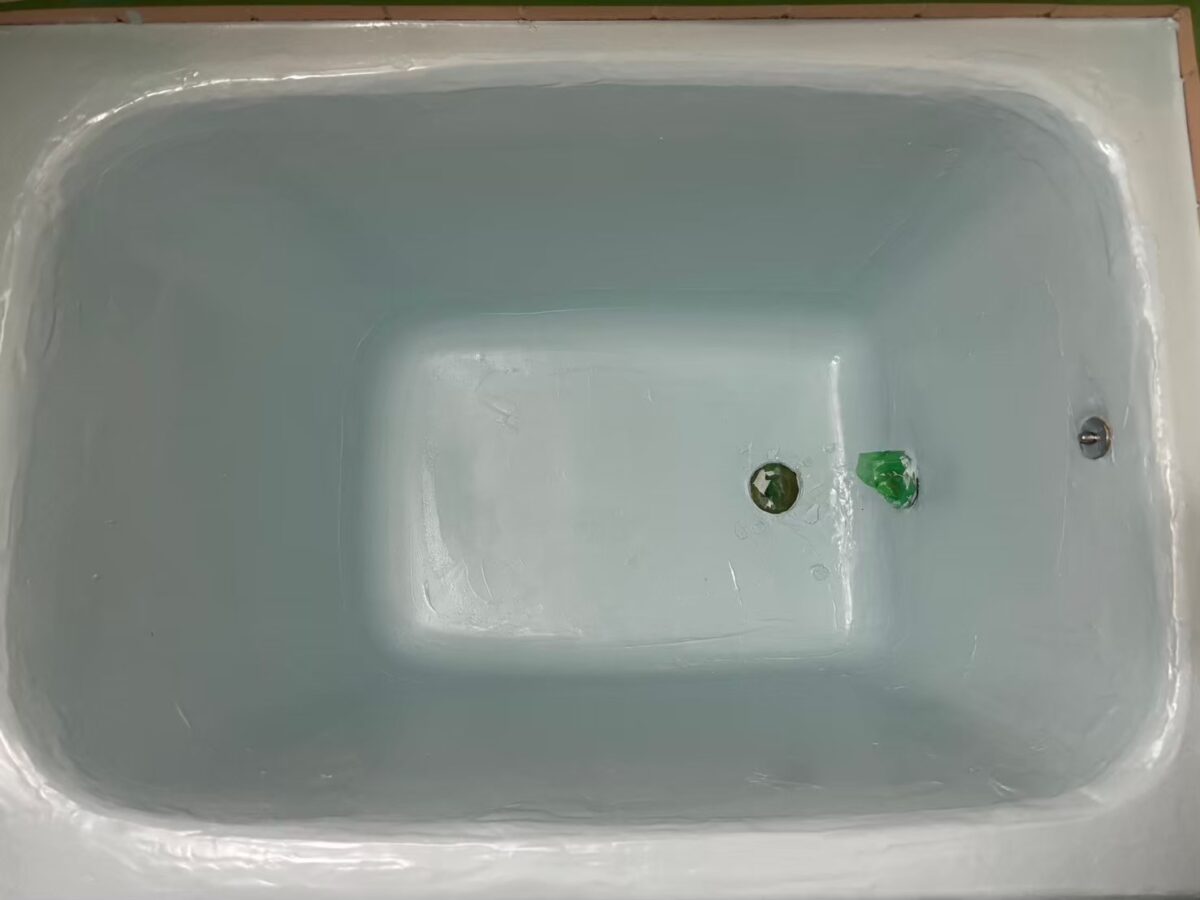 工事の途中、浴槽の内側が淡い水色になった状態。ふちと底の面にならしたような跡がある
