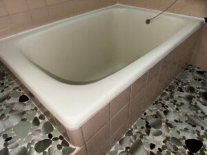 施工後、同じ角度から見たホーロー浴槽。ライトアイボリーでつやがあり、ふちとタイルの境目は白いラインになっている