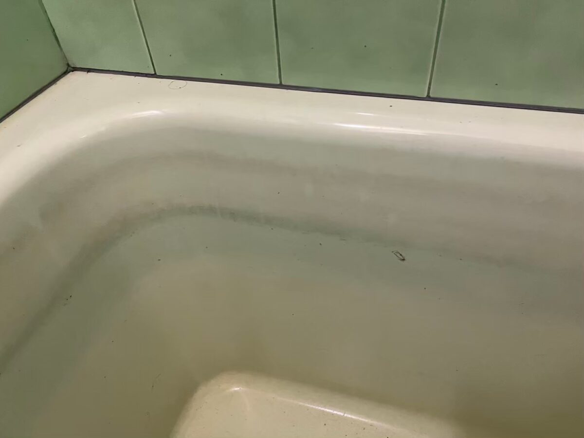 施工前、浴槽の内側の角の近く。帯状の水垢がこびりついている