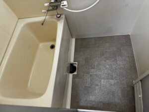 施工後、同じ角度から見た浴室。洗い場の床が石目調の床シートに変わっている