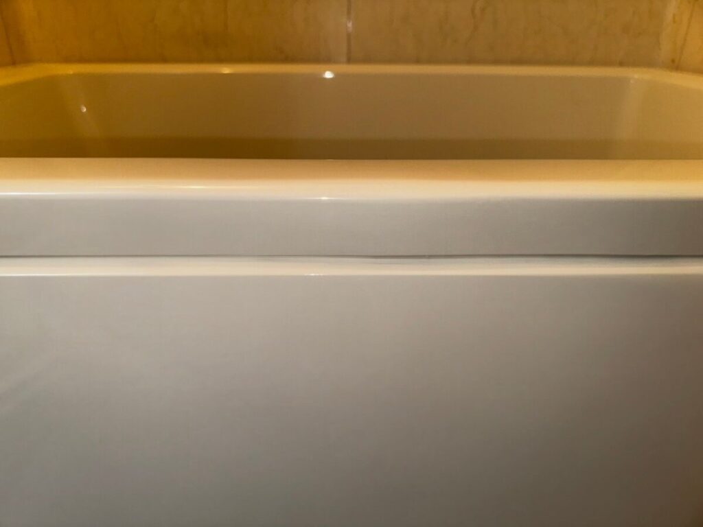 施工後、浴槽のふち(フランジ)の合わせ目を同じ位置から見たところ。亀裂と黒っぽい汚れは見えない