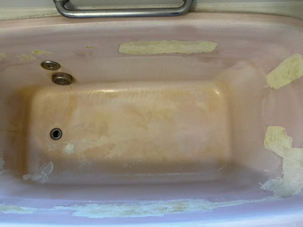施工前、浴槽を真上から近くで見たところ。底はオレンジがかった色でまだらになっている