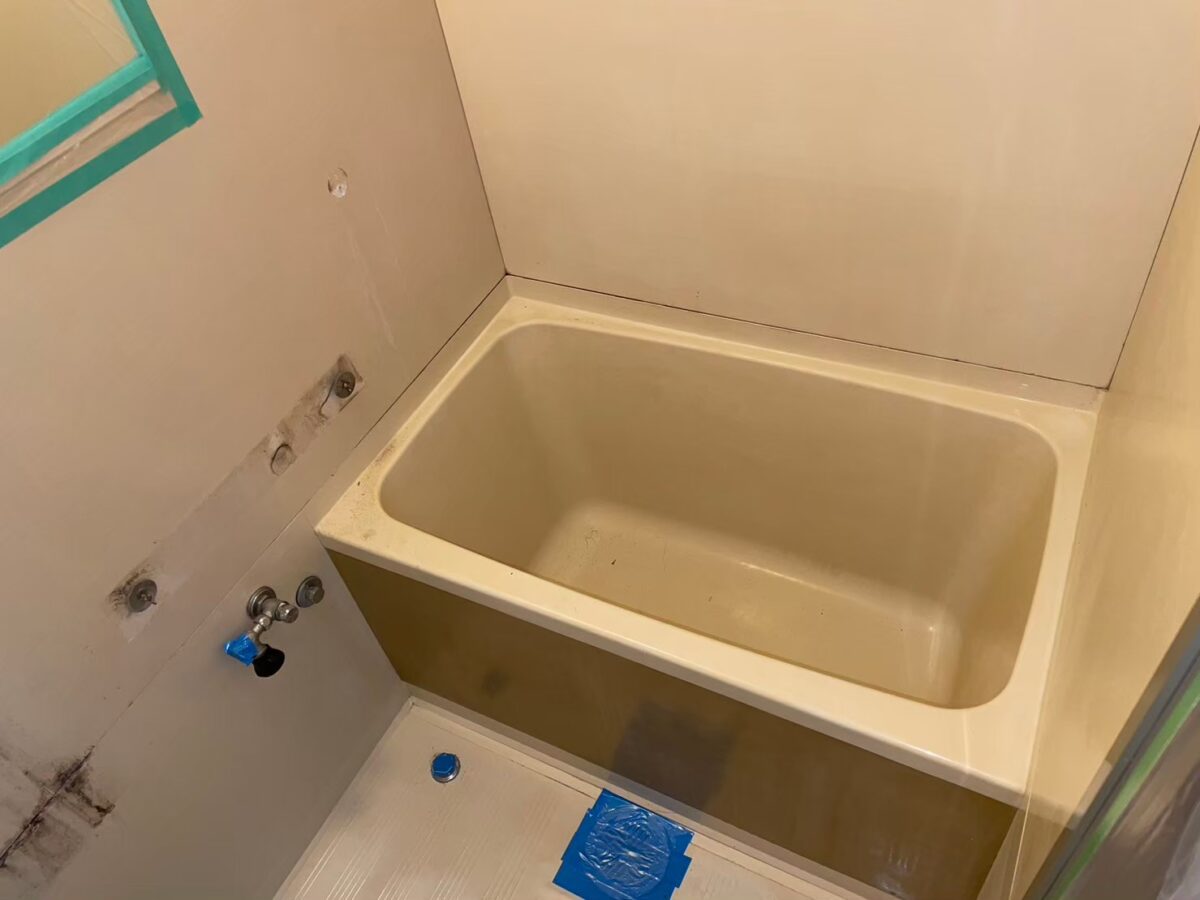 施工前、ユニットバスの浴槽を横から見たところ。エプロンは茶色っぽく、内側はベージュ色にくすんでいる