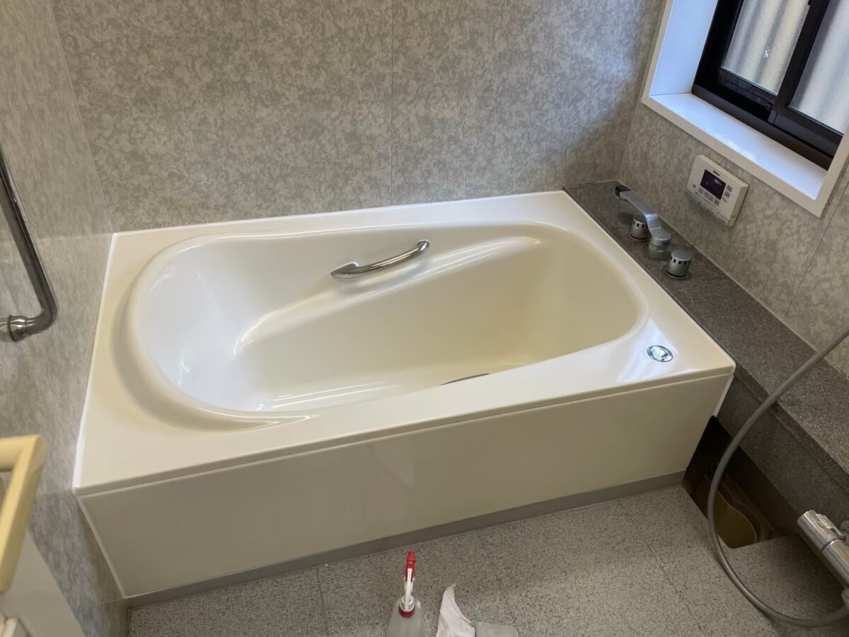 施工後、窓が見える角度から浴室を見たところ。浴槽の内側までつやのあるライトアイボリー