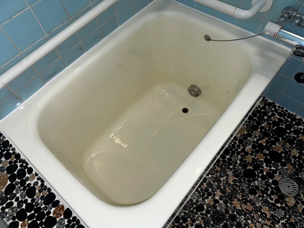 施工後、浴槽を斜め上から見たところ。ふちと壁のタイルの境目が白く整っている