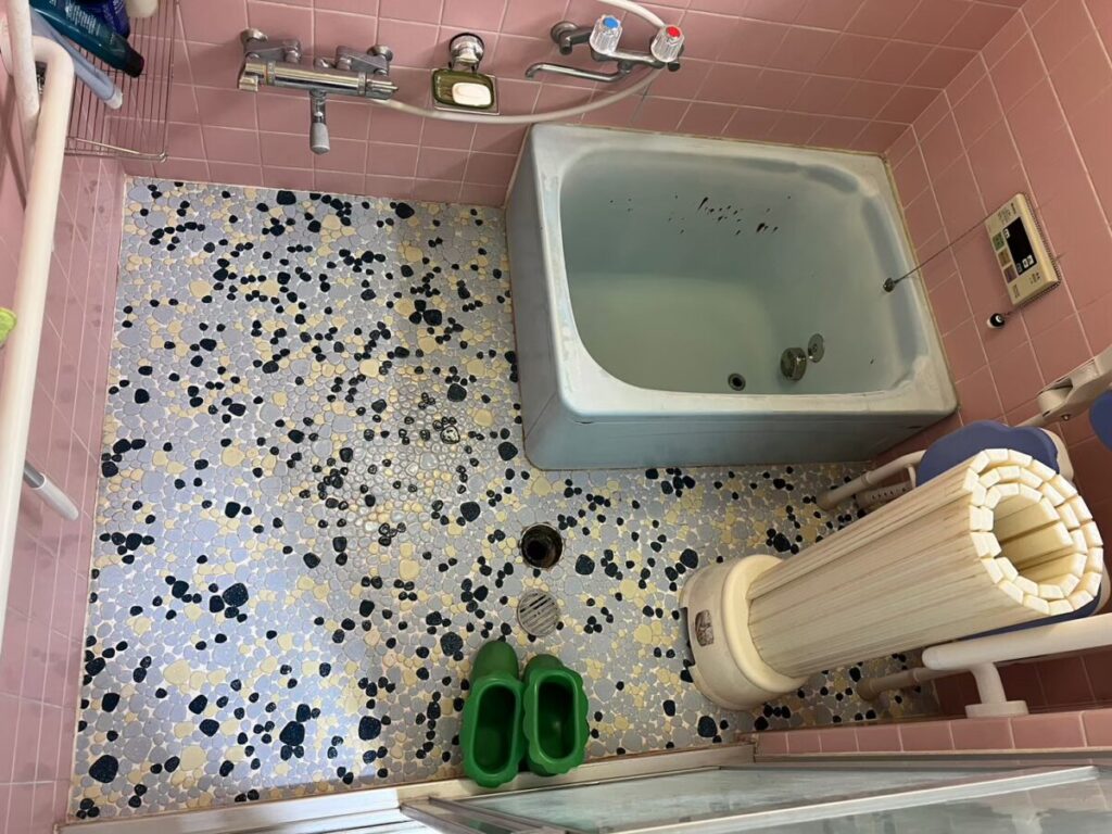 豊岡市の施工前、小石模様のモザイクタイル床と、サビが出た水色のホーロー浴槽の浴室