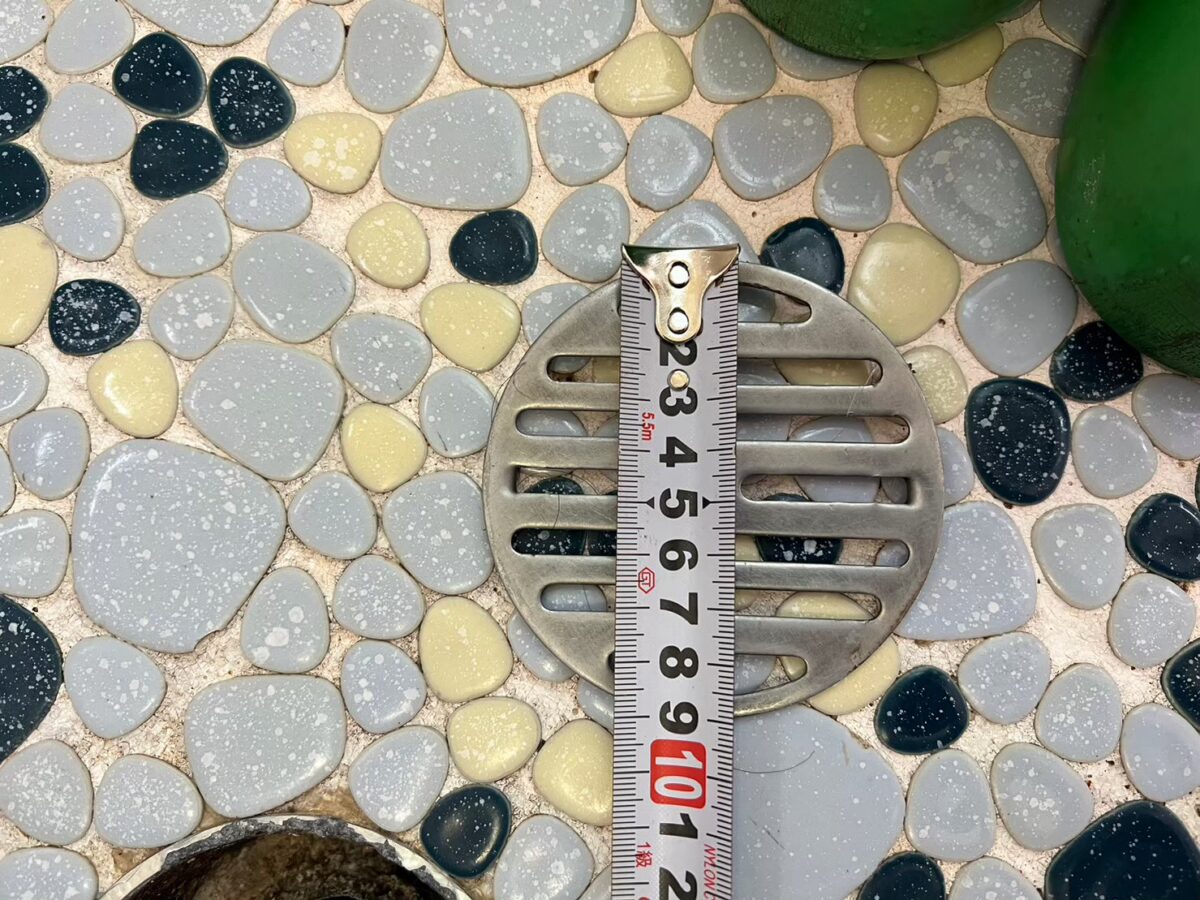 床の排水口の大きさを採寸している様子