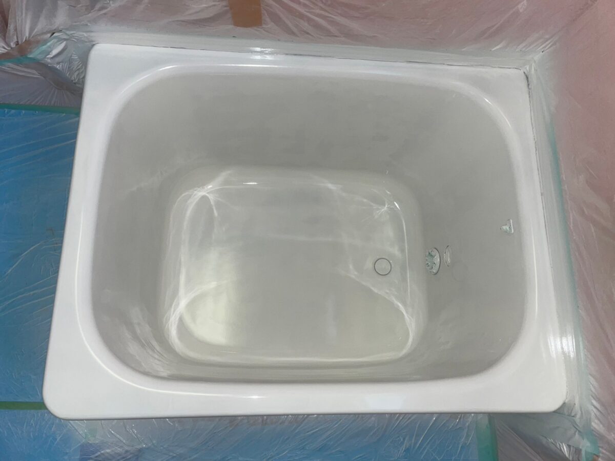 ベースコートを吹き付けた浴槽。まわりを養生している