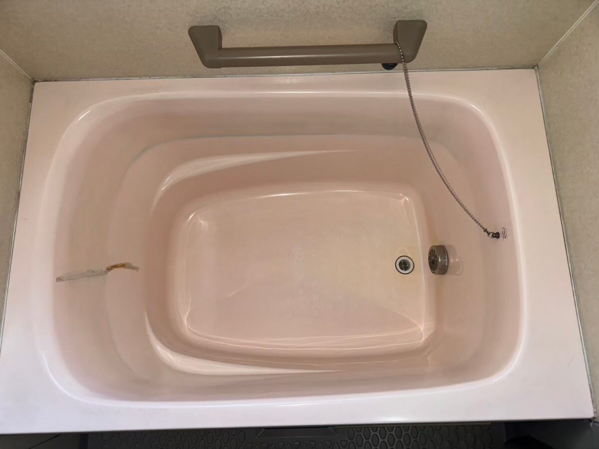 施工前、ピンク色の浴槽を真上から見たところ。内側の壁面にひび割れの線が入っている