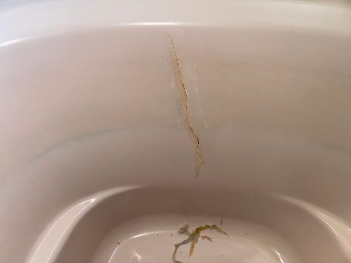 施工前、浴槽の内側に入ったひび割れのアップ。茶色い線になって目立っている